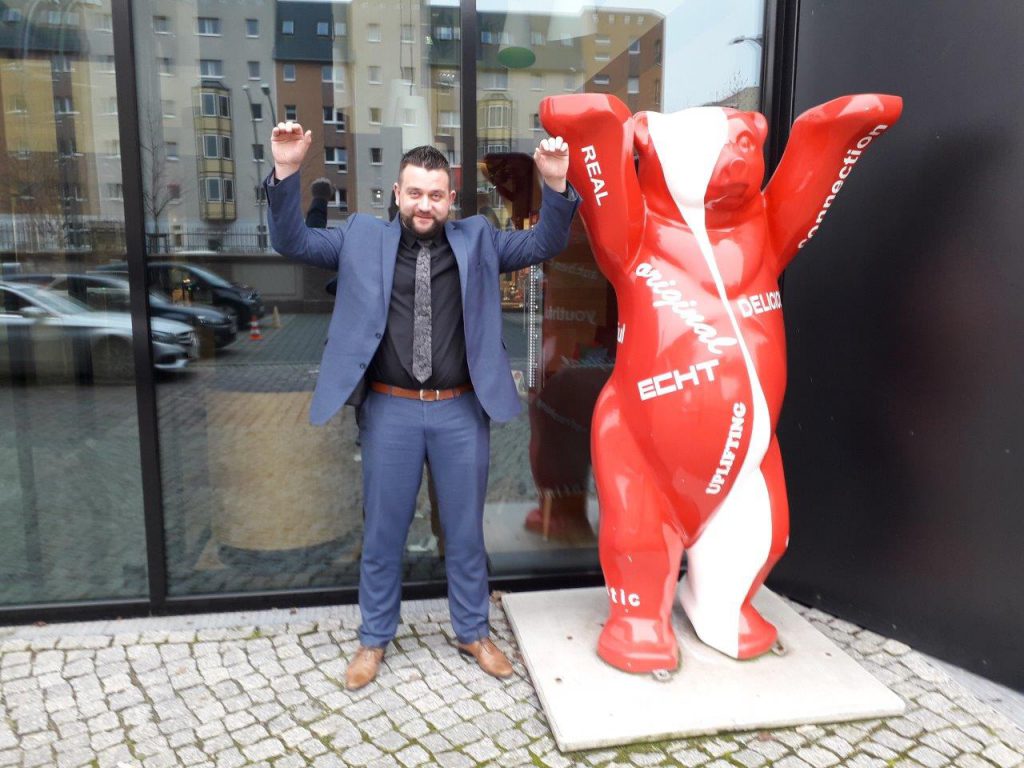 man next to a bear statue