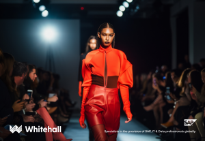 A young lady walking down a fashion catwalk. She is wearing a bright orange outfit