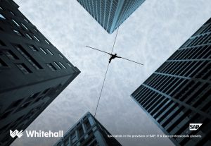 A person walking a long a tight rope in-between four buildings